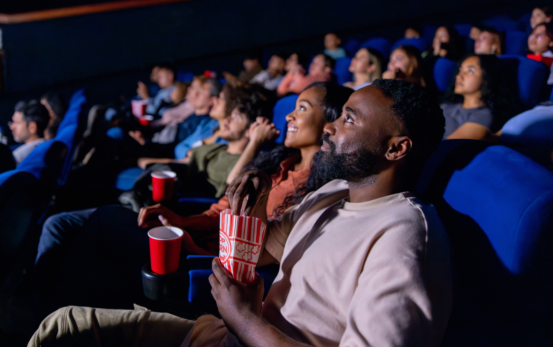 Couple Watching A Movie At The Theatre And Eating Popcorn